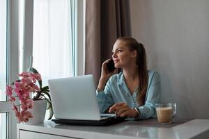 ein jung schön Mädchen beim Zuhause ist Arbeiten auf ein Laptop, diskutieren Geschäft Ideen mit ein Partner foto