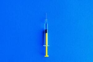 Gelb Glas medizinisch Spritze Über Blau Hintergrund foto