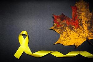 Kindheit Krebs Bewusstsein Tag. Gelb Band auf schwarz Hintergrund. foto