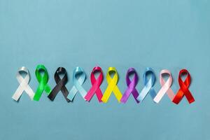 Welt Krebs Tag. bunt Bänder, Krebs Bewusstsein, Blau Hintergrund. International Agentur zum Forschung auf Krebs foto