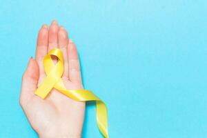 Gelb Krebs Bewusstsein Band mit Weg auf Weiß Hintergrund. Konzept von Gesundheit und Medizin foto