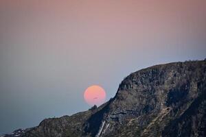 Westkap im Norwegen. Berg Das erreicht in das Fjord. Mond leuchtenden rot foto