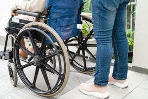 Pflegekraft Hilfe und Pflege asiatisch Senior Frau geduldig Sitzung auf Rollstuhl zu Rampe im Pflege- Krankenhaus, gesund stark medizinisch. foto