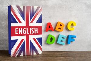 Wort Englisch auf Buch mit vereinigt Königreich Flagge, Lernen Englisch Sprache Kurse Konzept. foto