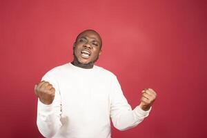 Ich bin Gewinner. Porträt von glücklich afrikanisch amerikanisch Mann isoliert Über rot Hintergrund. foto