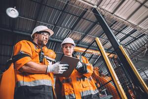 Ingenieur Mannschaft Bedienung Roboter Schweißen Arbeiten im Automatisierung Fabrik. Menschen Arbeiter im Sicherheit passen Arbeit Roboter Arm Software Programmierung oder ersetzen Teil im automatisiert Herstellung Industrie Technologie. foto