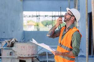 Ingenieur Baumeister Vorarbeiter Arbeit Radio Anruf im Konstruktion Seite? ˅. Architekt Arbeiter Projekt Designer Führer Konzept. foto