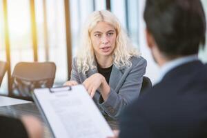 jung Geschäft Frau konzentriert Augen zuversichtlich sich unterhalten zu Ihre Boss aufmerksam im Büro Treffen Zimmer zum Job Interview foto