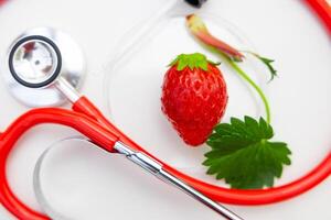 Erdbeere hoch Ernährung Vitamin zum gut Gesundheit Konzept. Nahansicht Erdbeeren Obst mit Stethoskop. foto