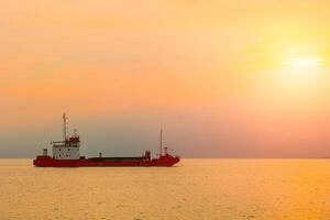 Transport Ladung Boot Schiff mit Sonnenuntergang Meer Ozean Versand zum importieren Export Industrie Szene Aussicht foto