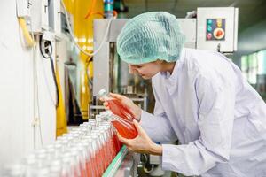 Essen und trinken Industrie Mitarbeiter Arbeiter Arbeiten beim Förderer Gürtel Produktion Linie Maschine im Getränk Fabrik mit sauber und Hygiene Bereich. foto