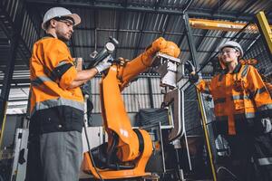 Ingenieur Mannschaft Bedienung Roboter Schweißen Arbeiten im Automatisierung Fabrik. Menschen Arbeiter im Sicherheit passen Arbeit Roboter Arm Software Programmierung oder ersetzen Teil im automatisiert Herstellung Industrie Technologie. foto