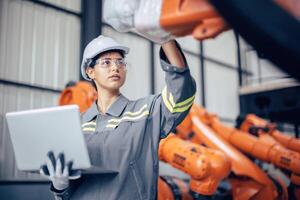 Ingenieur Frau Arbeiten im voraus Maschine Fabrik. indisch weiblich Ingenieurwesen Mitarbeiter Arbeit Überprüfung Roboter Arm im Versammlung Pflanze foto