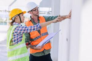 Ingenieur Baumeister Mannschaft Arbeiten beim Konstruktion Seite? ˅ Überprüfung bauen Qualität von Mauer Beton Verputzen foto