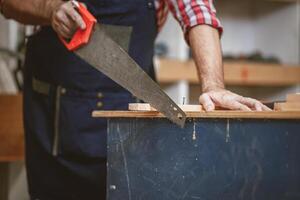 Zuhause Baumeister Arbeiten Schneiden Holz Panel mit sah Werkzeug. DIY Holz Werkstatt Herstellung Möbel. foto