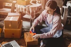 Frau Verpackung Produkte bestellen Box senden zu Kunde freiberuflich Arbeit zum besitzen Geschäft beim Zuhause Jahrgang Ton foto