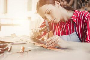 Frau Leder Schneider Künstler Handwerk Arbeiten beim besitzen Werkstatt klein Studio gemacht durch bestellen Meisterwerk Stück foto