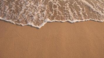 Weiß schaumig Hintergrund von Wellen abstürzen auf ein sandig Strand. foto