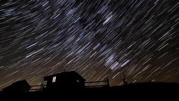 hölzern Haus im das Berge im Winter. Star Wanderwege im das Nacht Himmel. foto