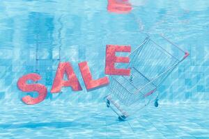 Einkaufen Wagen und Verkauf Zeichen untergetaucht im Schwimmbad Wasser foto