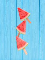 Wassermelone Eis am Stiel gegen Blau hölzern Hintergrund foto