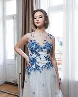 ein Frau im ein Weiß Kleid mit Blau Blumen foto