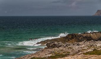 die wellen kämpfen um die verlassene felsige küste des atlantiks, portugal foto