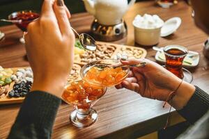 Person Gießen rot Wein in ein Wein Glas beim ein schick Abendessen foto