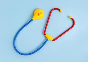 Spielzeug Stethoskop auf ein Blau Hintergrund. Kinder- Medizin. Pädiatrie. Arzt Spiel. foto