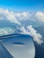Aussicht von ein Flugzeug von das Motor und das Wolken Über das Malediven. foto