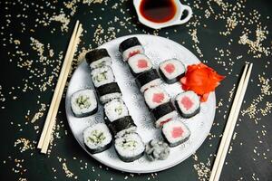 Teller von Sushi mit Essstäbchen und ein Tasse von Tee foto