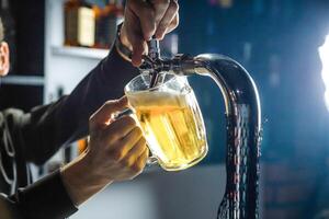 ein Mann Gießen Bier in ein Glas beim ein Bar Zähler foto