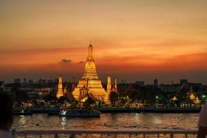 wat arun Tempel im Sonnenuntergang, Tempel von Dämmerung in der Nähe von Chao Phraya Fluss. Wahrzeichen und Beliebt zum Tourist Attraktion und Reise Ziel im Bangkok und Süd-Ost Asien. Bangkok, Thailand, 05 Januar 2024 foto