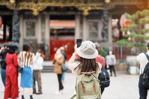 Frau Reisender Besuch im Taiwan, Tourist mit Hut Besichtigung im Longshan Tempel, Chinesisch Volk religiös Tempel im wanhua Bezirk, Taipeh Stadt. Wahrzeichen und beliebt. Reise und Ferien Konzept foto