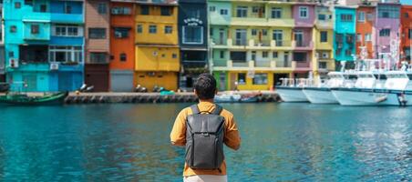 Mann Reisender Besuch im Taiwan, Tourist mit Rucksack Besichtigung im Kiel, bunt zhengbin Angeln Hafen, Wahrzeichen und Beliebt Sehenswürdigkeiten in der Nähe von Taipeh Stadt . Asien Reise Konzept foto