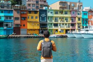 Mann Reisender Besuch im Taiwan, Tourist mit Rucksack Besichtigung im Kiel, bunt zhengbin Angeln Hafen, Wahrzeichen und Beliebt Sehenswürdigkeiten in der Nähe von Taipeh Stadt . Asien Reise Konzept foto