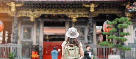 Frau Reisender Besuch im Taiwan, Tourist mit Hut Besichtigung im Longshan Tempel, Chinesisch Volk religiös Tempel im wanhua Bezirk, Taipeh Stadt. Wahrzeichen und beliebt. Reise und Ferien Konzept foto