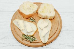 Stücke von reif Birne mit Camembert Käse mit Croutons auf das Tabelle foto