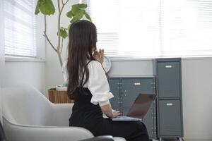 ein Arbeiten japanisch Frau durch Fernbedienung Arbeit im das Zuhause Büro Nahansicht foto