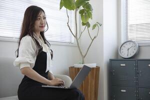 ein Arbeiten japanisch Frau durch Fernbedienung Arbeit im das Zuhause Büro Nahansicht foto