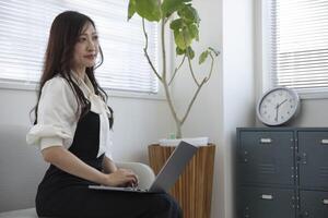 ein Arbeiten japanisch Frau durch Fernbedienung Arbeit im das Zuhause Büro Nahansicht foto