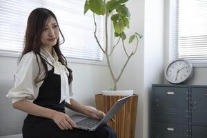 ein Arbeiten japanisch Frau durch Fernbedienung Arbeit im das Zuhause Büro Nahansicht foto