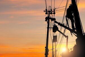 Die Silhouette des Elektrikers klettert auf einen Mast und verwendet eine Seilbahn, um ein Hochspannungsleitungssystem zu warten, Schatten des Elektrikers, Lineman, Reparaturarbeiter bei Kletterarbeiten am Strommast foto