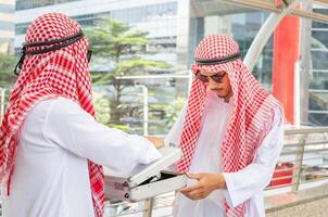 arabisch Geschäft Mannschaft diskutieren im das Morgen, Geschäft Mann ist Gehen durch das Stadt Straße foto