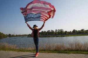 jung Mädchen mit ein Schal im das Farbe von das amerikanisch Flagge durch das Fluss.selektiv Fokus foto