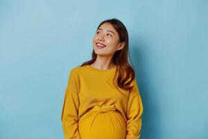 ai generiert schwanger asiatisch Frau hält Hand auf Bauch. steht nachdenklich gegen Blau Hintergrund foto