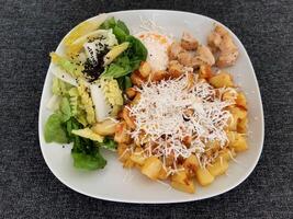 hausgemacht gegrillt Hähnchen mit Französisch Fritten, Käse und Grün Salat, serviert auf ein Weiß Teller foto