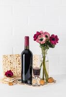 festlich Komposition zum das jüdisch Passah. ein Flasche von koscher Wein, Matze, ein Kristall Glas von Wein, ein traditionell Essen zum feiern foto