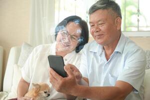 Alte Frauen und Männer benutzen ihr Smartphone auf dem Sofa. foto