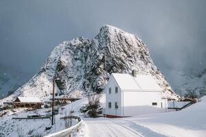 Weiß Haus mit Kabeljau Fisch Industrie und Schnee Berg im schneit Tag beim Lofoten Inseln foto